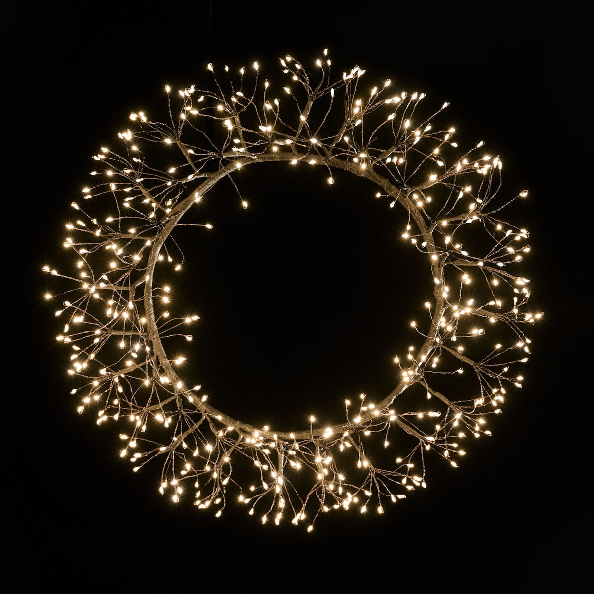 Decoratiune de Craciun luminoasa sub forma de coronita rotunda cu leduri aprinse suspendata pe un perete